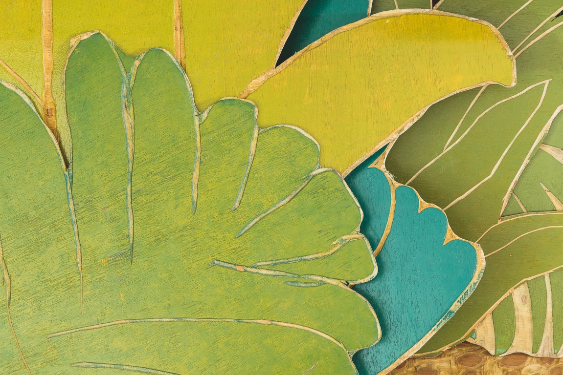Descrição da imagem: fotografia horizontal que exibe o detalhe das matrizes coloridas do ateliê de Santídio Pereira. As peças estão sobrepostas umas as outras. As peças são em formatos de folhas ou flores e possuem cores variadas, como verde claro, verde escuro, verde azulado e amarelado. Fim da descrição da imagem.