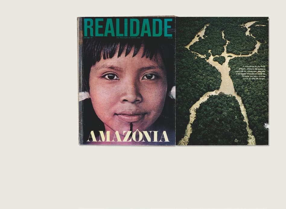 Descrição da imagem: Imagem colorida de uma capa da revista "REALIDADE" aberta. Na capa, à esquerda, o rosto de uma criança indígena da etnia Uaicá. em close e a palavra "AMAZÔNIA" logo abaixo. Ela tem um rosto redondo, cabelos lisos pretos com franja na altura da testa, e tem um adorno de uma linhas vertical que vai do centro do lábio inferrior até a base do queixo, em tinta preta. À direita da imagem, uma vista aérea do rio Paru com a seguinte legenda: "A corredeira do rio Paru d'Oeste, afluente da margem esquerda do Amazonas, desenha a figura humana no verdade da floresta. Ao lado, menina uaicá, do alto rio Negro". Fim da descrição.