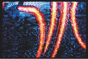 Descrição da imagem: Imagem colorida e horizontal. A imagem mostra uma tela eletrônica com interferência, exibindo padrões abstratos em tons de azul, roxo e preto. Três linhas verticais onduladas e brilhantes em vermelho e laranja atravessam a imagem da parte superior à inferior, criando um efeito de distorção. O visual é caótico, sugerindo uma falha na transmissão ou recepção de sinal. Fim da descrição da imagem.