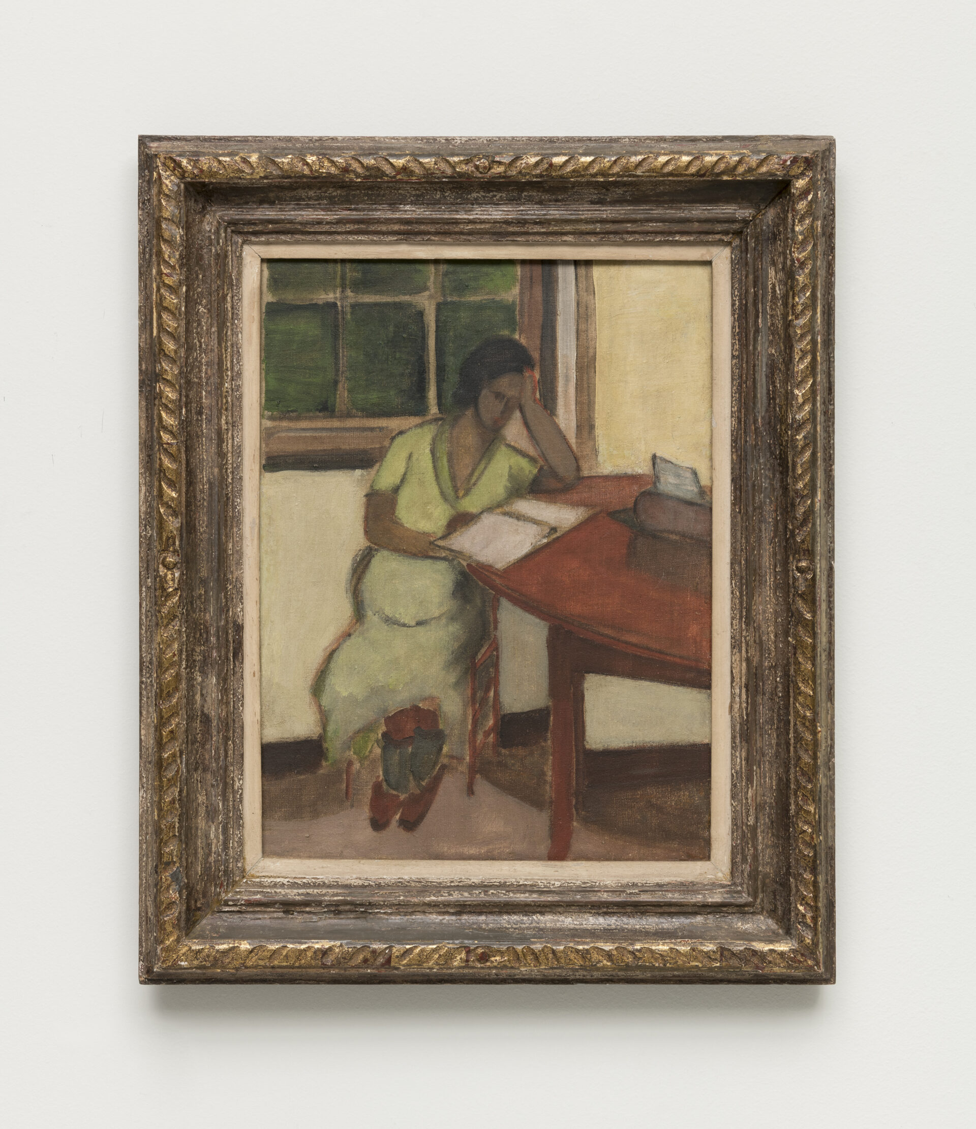 Descrição da imagem: Pintura de uma mulher grávida sentada a uma mesa. Ela é negra e tem cabelos pretos lisos, amarrados em um coque. Os olhos, o nariz e a boca são apenas um leve contorno. Ela usa um vestido longo verde-claro, meias verde-acinzentadas e sapatos marrons. Está sentada de lado em uma cadeira, com a mão esquerda apoiada na testa e a direita diante de um caderno aberto sobre a mesa, que é circular e de madeira. Ao fundo, uma parede amarelada e uma janela fechada. O chão é bege. A moldura é dourada. Fim da descrição. 
