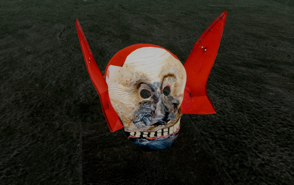 Imagem. Descrição da imagem: A imagem mostra um objeto tridimensional que se assemelha a uma máscara ou crânio estilizado, posicionado sobre uma base escura em um ambiente virtual. O rosto é de cor bege clara com manchas escuras e buracos nos olhos. O que se destaca são duas grandes abas ou "orelhas" pontiagudas de cor vermelho vibrante que saem das laterais da cabeça, assemelhando-se a asas de plástico ou metal. O fundo é escuro e texturizado. Fim da descrição da imagem.